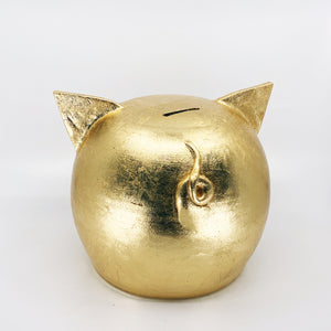 Elegant golden piggy bank with intricate detailing, perfect for home decor and savings inspiration.
